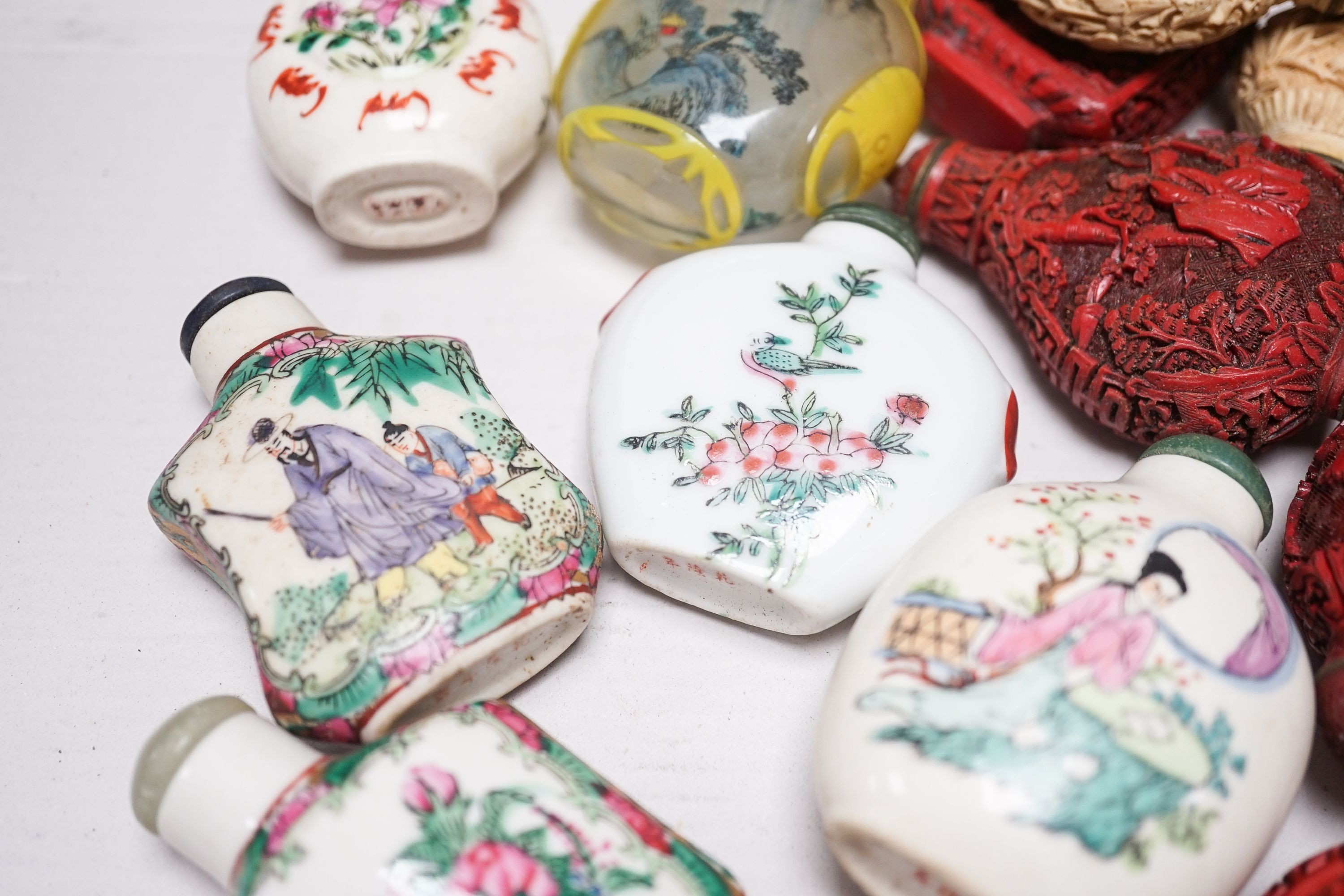 A collection of Chinese snuff bottles, 20th century, including a carved cinnabar lacquer and hardstone inlaid snuff bottle, 7.4cm (23)